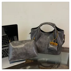 Three-piece dark gray vintage PU leather bucket bag set with matching pouch and charm