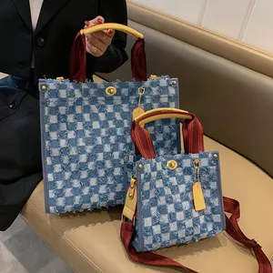 Blue denim checkerboard tote bag with distressed edges and red striped handles