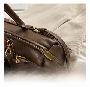 Detail of premium gold-toned hardware and rich brown leather texture on a baguette bag