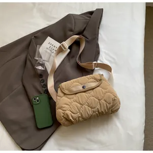 Detailed view of beige quilted crossbody bag with rhombic stitching and wide strap
