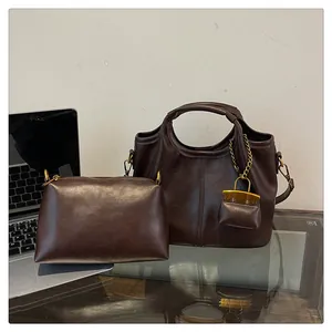 Detail view of dark brown leather bucket bag set with polished gold hardware and inner pouch