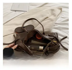Detail of the spacious interior and striped lining of the large brown leather shoulder bag