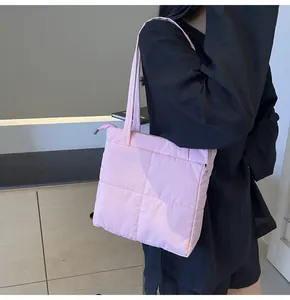 Detail of pink quilted tote bag showing thick padded texture and sleek metal zipper closure
