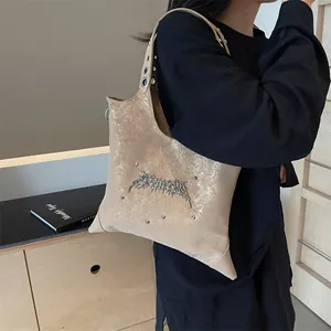 Borsa tote dorata metallizzata a forma di stella con dettagli gotici e tracolla borchiata