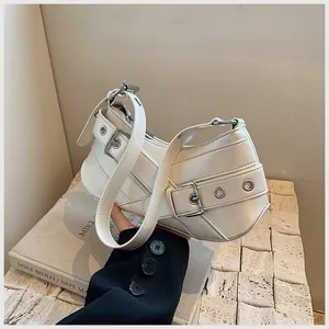 Detail view of cream crescent underarm bag with silver buckles and leather straps