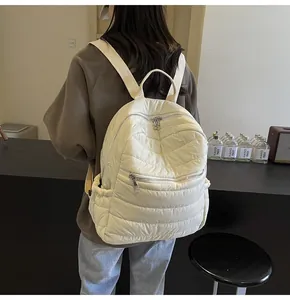 Rückansicht des Models mit beigem gestepptem Rucksack aus leichtem Luftpolsterstoff