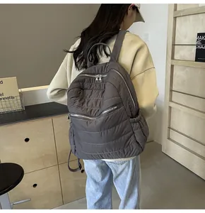 Makro-Detail von dunkelgrauem gestepptem Rucksack mit Reißverschlüssen und Seitentasche am Model