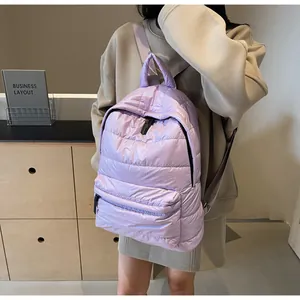 Detail of lavender quilted puffer backpack with glossy finish and soft texture on model