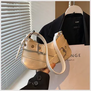 Detailed close-up of cream underarm bag featuring metallic buckle and eyelet strap