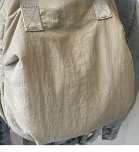 Close-up of khaki lightweight nylon backpack with reinforced stitching on the handle