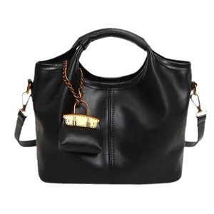 Classic black leather bucket bag with top handle and mini decorative charm accessory
