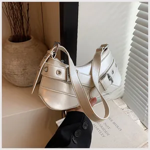 Detail view of cream moon bag featuring adjustable metal eyelets and thick shoulder strap