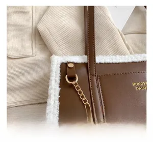 Detail view of leather tote with plush faux fur trim and elegant gold chain strap hardware
