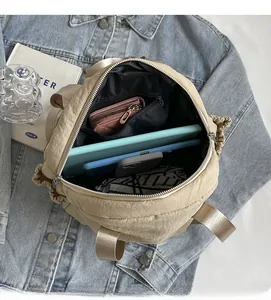 Spacious interior of beige quilted puffer bag showing pockets and storage capacity