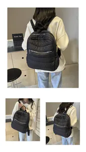 Details des schwarzen gesteppten Rucksacks mit silbernen Reißverschlüssen und Nylonstruktur
