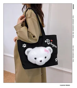 Detail showing high-quality black canvas tote bag with 3D plush bear and stylish embroidery