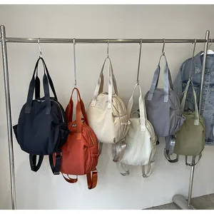 Variety of colorful lightweight nylon backpacks hanging on a metal display rack