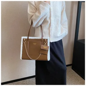 Detail view of brown faux leather tote bag with white plush trim and hanging coin purse
