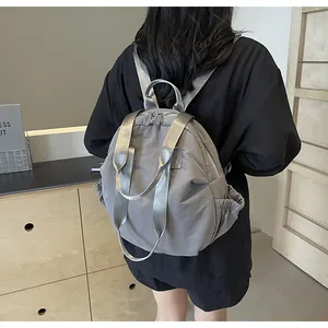 Rear view of grey quilted nylon backpack featuring wide webbing straps and side pockets