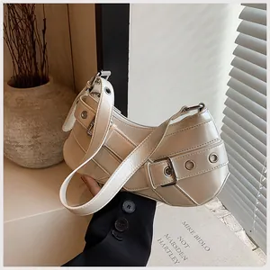Detailed close-up of cream underarm bag with glossy pearl finish and buckle strap