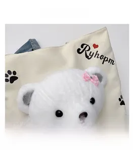 Detail of canvas tote bag featuring a 3D plush bear head with pink lace bows