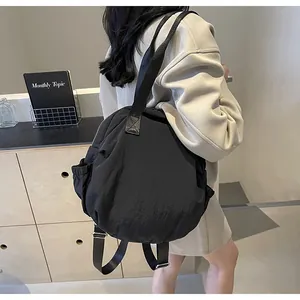 Detail of adjustable padded shoulder straps and drawstring side pocket on black travel backpack