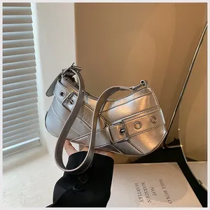 Detailed macro view of silver metallic underarm bag with buckle straps and eyelets