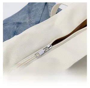 Close-up detail of smooth metal zipper and canvas texture on white bear tote bag