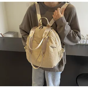Detail of beige travel backpack with side elastic pocket and lightweight nylon texture