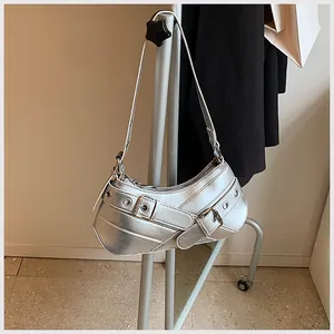Detail of silver metallic underarm bag with decorative belt buckles on a minimalist hanger