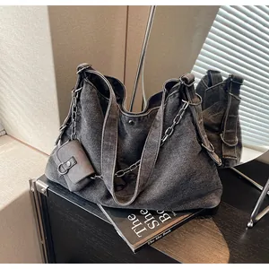 Detail of large denim tote bag featuring metal chain and a detachable mini coin pouch