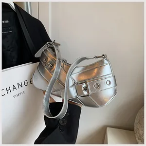 Close-up of metallic silver moon bag with grommet details and adjustable buckles
