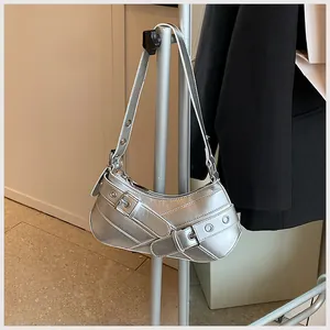 Macro detail of silver metallic crescent bag with buckle straps and metal eyelets