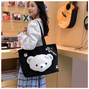 Detail of cute plush bear head and paw prints on a black canvas tote shoulder bag