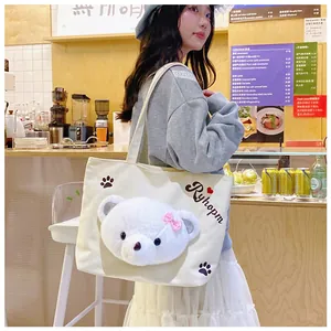 Detail of canvas tote bag with 3D plush bear and Ryhopm print in cafe setting