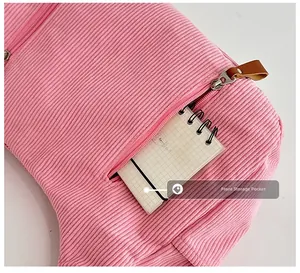 Detailed macro view of pink corduroy texture and front zipper pocket with leather pull
