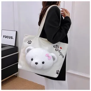 Close-up of white canvas tote bag with 3D plush bear head and pink bow detail