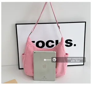 Pink corduroy crossbody bag size comparison with an iPad showing its medium capacity