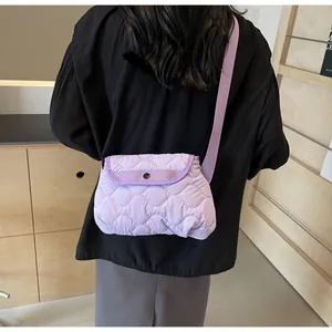Detailed back view of purple quilted crossbody bag showing size and wavy stitch pattern