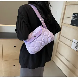 Detail of purple quilted cloud crossbody bag featuring wave patterns and snap button