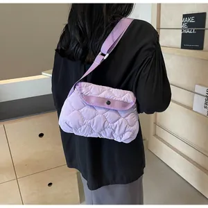 Detail of light purple quilted crossbody bag featuring soft cloud texture and metal snap closure