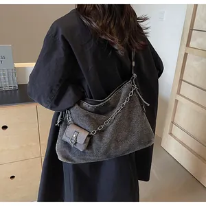 Detail of gray denim tote bag with thick metal chain and mini coin pouch accessory