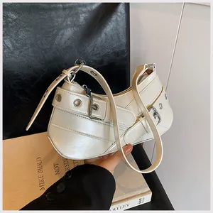 Detail of off-white crescent bag featuring silver eyelets and leather belt buckle strap