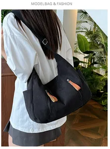 Detail showing the black corduroy texture and side zipper pockets of the large crossbody bag