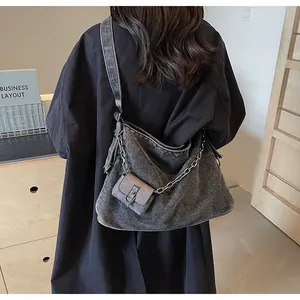 Detailed close-up of large grey washed denim tote bag with stylish silver chain strap