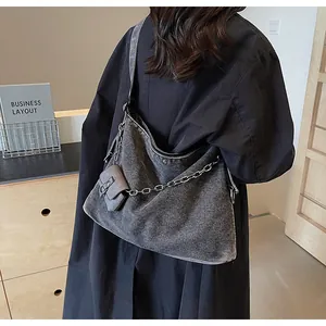 Detailed shot of large denim tote bag with silver chain and detachable mini pouch