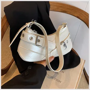 Detail of white PU leather underarm bag with silver grommets and belt buckle decor