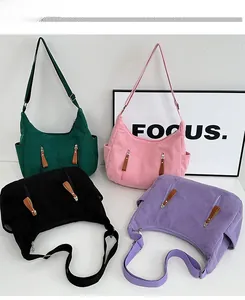 Detail of corduroy dumpling bags in green, pink, black, and purple with dual zippers