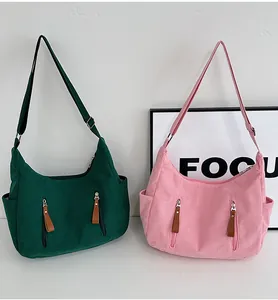 Detail of corduroy dumpling bags showing vertical texture, zipper pockets and side slots
