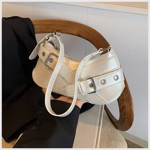 Detail of cream white underarm bag with silver metal buckles and decorative strap